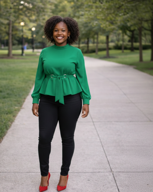 Woman wearing a green peplum top and black pants with red shoes in a park setting
